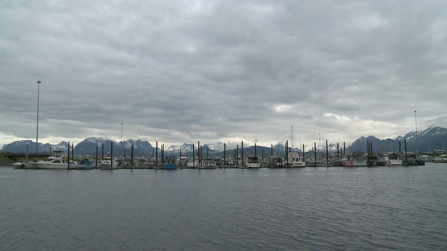 “阿拉斯加霍默船港(Homer Boat Harbor)的休闲游艇视野开阔，背景是卡切马克湾州立公园(Kachemak Bay State Park)的雪山和荒野公园(Wilderness Park)，霍默斯唾沫(Homer Spit)，霍默，基奈半岛(Kenai Peninsula)。”视频素材