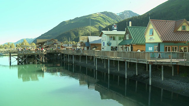 “木板路上五颜六色、风景如画的建筑，背景是楚加奇国家森林的青山，阳光明媚的日子，阿拉斯加基奈半岛苏厄德。”视频素材