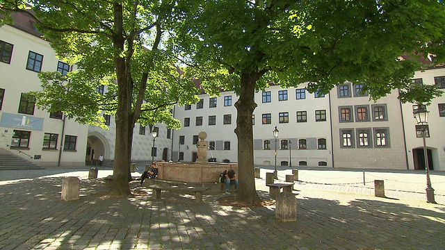 Alter Hof, place, man on bike, tree, building, architecture, tree, fountain, people, sunny，平移拍摄视频素材