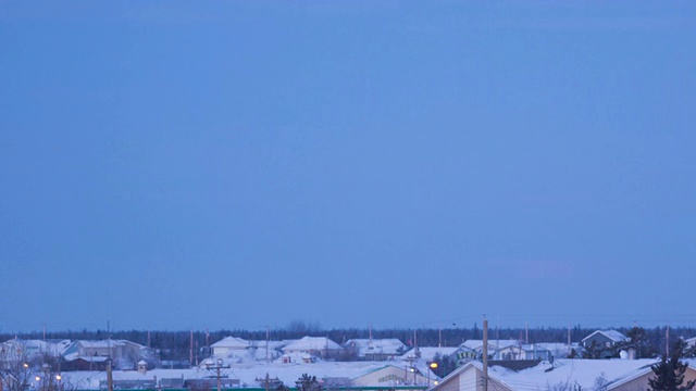 WS T/L满月在被雪覆盖的市中心落下的景象/耶洛奈夫，加拿大西北地区视频素材