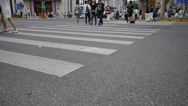 行人在城市街道斑马线上行走，时间流逝。视频素材