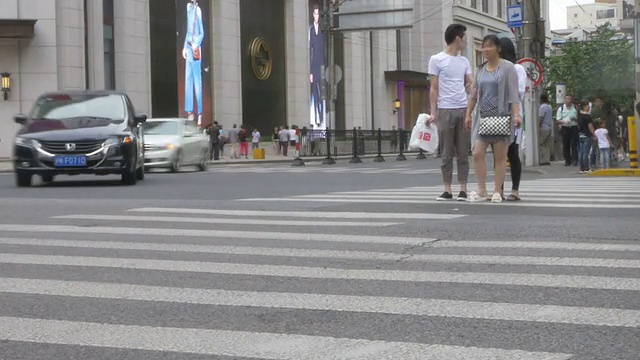 行人在城市街道斑马线上行走，时间流逝。视频素材