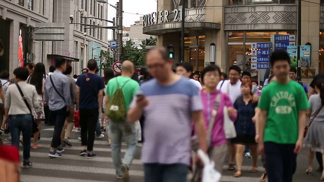 行人在城市街道斑马线上行走，实时。视频素材