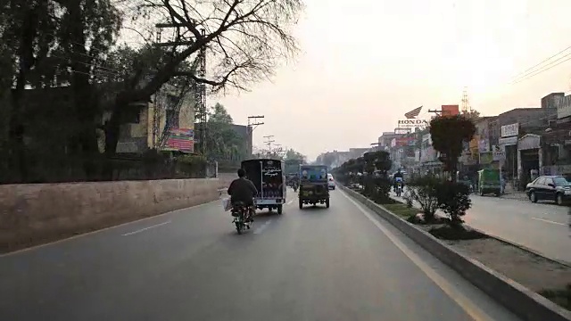 开车穿过拉合尔的街道，经过摩托车，嘟嘟车，汽车等。视频素材