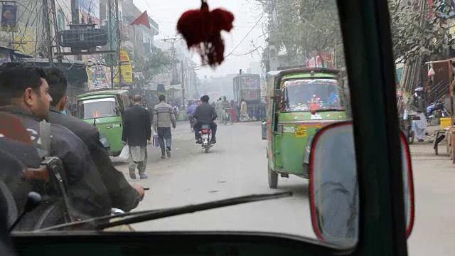 开车穿过拉合尔的街道，经过摩托车，嘟嘟车，汽车等。视频素材