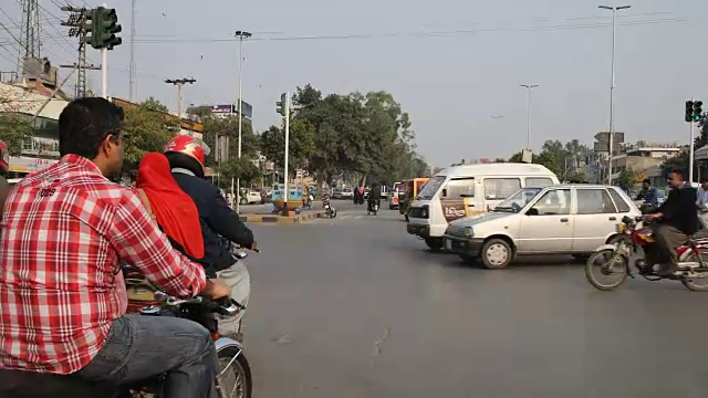 开车穿过拉合尔的街道，经过摩托车，嘟嘟车，汽车等。视频素材