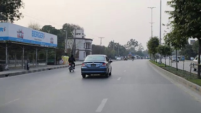 开车穿过拉合尔的街道，经过摩托车，嘟嘟车，汽车等。视频素材