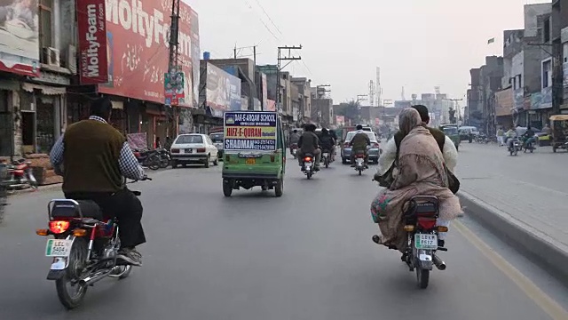 开车穿过拉合尔的街道，经过摩托车，嘟嘟车，汽车等。视频素材