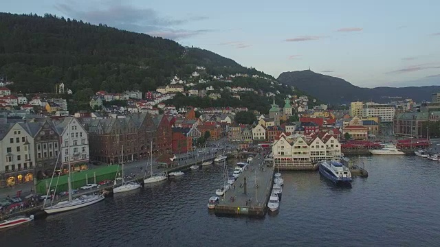 从Vågen海港俯瞰乌尔里肯山(Mount Ulriken)，位于挪威Hordaland卑尔根(Bergen)的老港区Bryggen，古老的中世纪汉萨式木制建筑上方视频素材