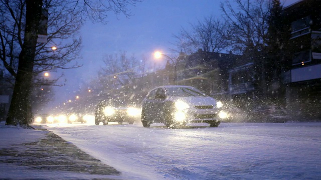 汽车在城市街道上行驶，天还在下雪视频素材