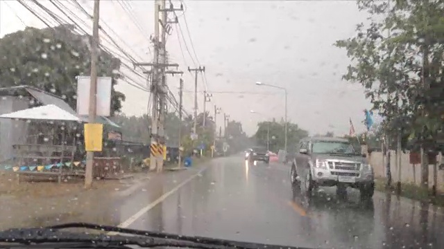 雨落在一辆正在行驶的汽车的挡风玻璃上。视频素材