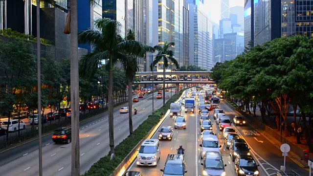 中国香港市中心告士打道的黄昏交通，在夜晚，汽车在道路上裸奔，在香港中环的摩天大楼旁边视频素材