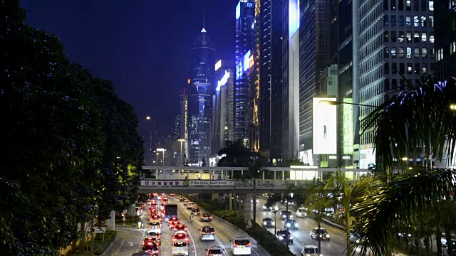 中国香港市中心告士打道的黄昏交通，在夜晚，汽车在道路上裸奔，在香港中环的摩天大楼旁边视频素材