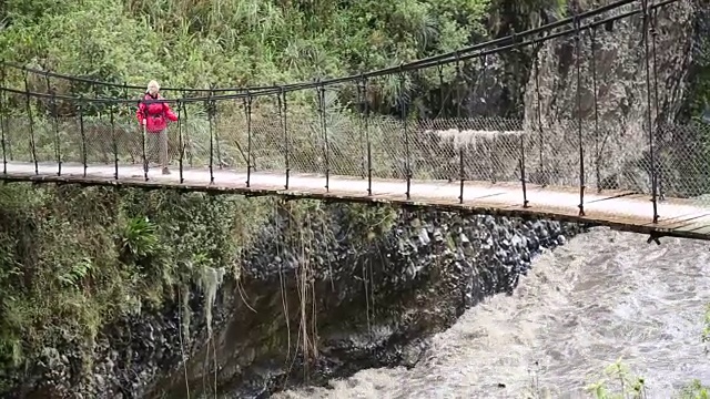 平底锅穿过悬索桥向女徒步旅行者视频素材