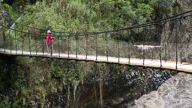 平底锅穿过悬索桥向女徒步旅行者视频素材