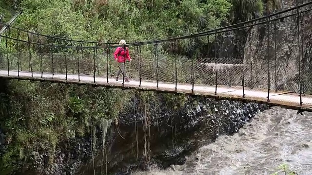 平底锅穿过悬索桥向女徒步旅行者视频素材