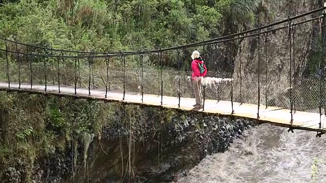 平底锅穿过悬索桥向女徒步旅行者视频素材