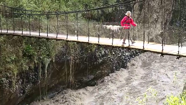 平底锅穿过悬索桥向女徒步旅行者视频素材