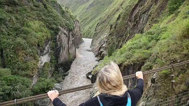 平底锅穿过悬索桥向女徒步旅行者视频素材