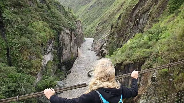 平底锅穿过悬索桥向女徒步旅行者视频素材