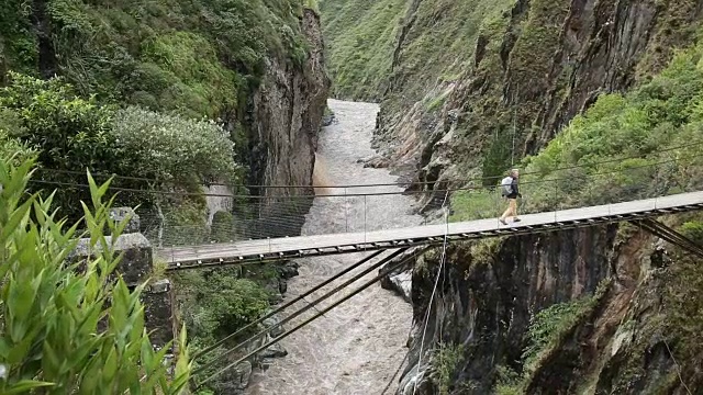 倾斜向下，男性徒步旅行者穿过吊桥视频素材