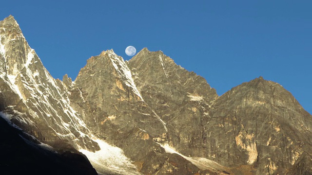 月亮在日出时经过喜马拉雅山峰的延时。裁剪。视频素材