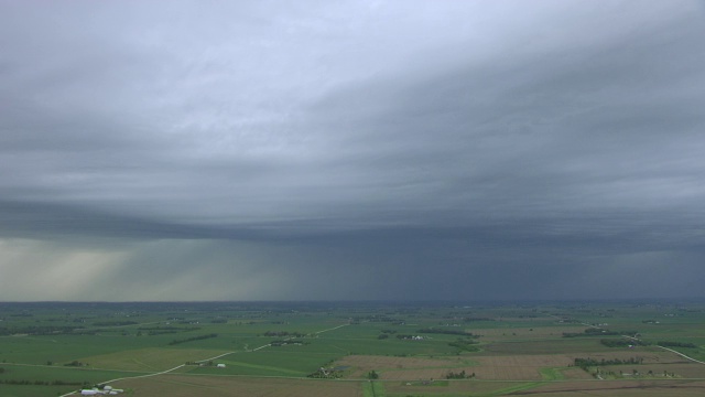 WS PAN AERIAL POV绿色农田与暴风雨的云/布坎南县，爱荷华州，美国视频素材