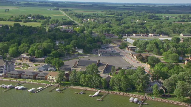 美国爱荷华州的WS AERIAL POV景观，在夏季前景中有建筑物和树木区域，码头和湖泊视频素材