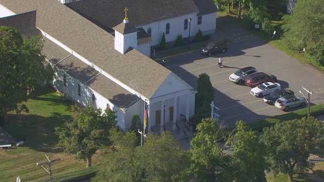 MS AERIAL POV St Francis Xavier教堂，街道上有车辆，美国马萨诸塞州海恩尼斯视频素材