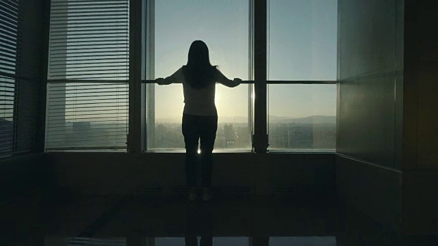 站在办公室窗边向外看的女人视频素材画面2