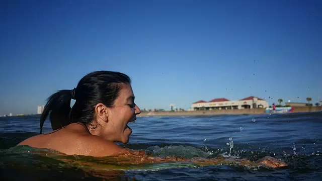 美丽的中年西班牙妇女喜欢骑冲浪而bodyboarding视频素材