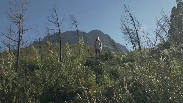 日出时分，一名年轻女子在山路上徒步旅行视频素材