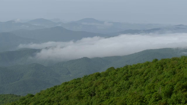 WS AERIAL POV山顶透过雾，山脉在远处/米切尔县，北卡罗来纳州，美国视频素材