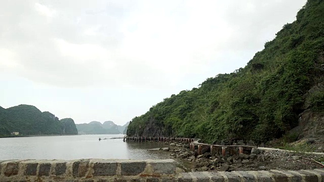 女孩沿着海湾走在砖墙上视频素材