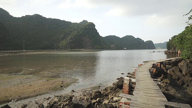 女孩沿着越南山下的海湾走在码头上视频素材