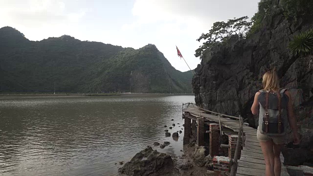 女孩沿着越南山下的海湾走在码头上视频素材