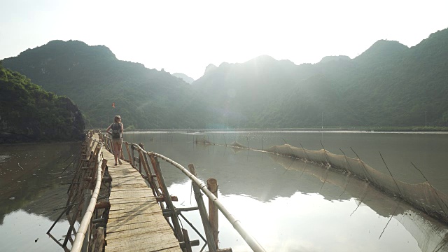 女孩沿着越南山下的海湾走在码头上视频素材