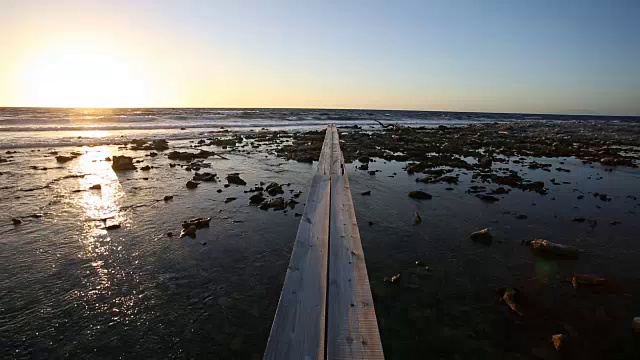 日出时，空码头正驶向大海。视频素材