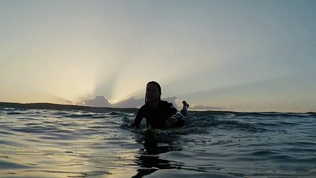 女冲浪者在日出时在法国南部大西洋海岸的荒芜沙滩上划桨。视频素材