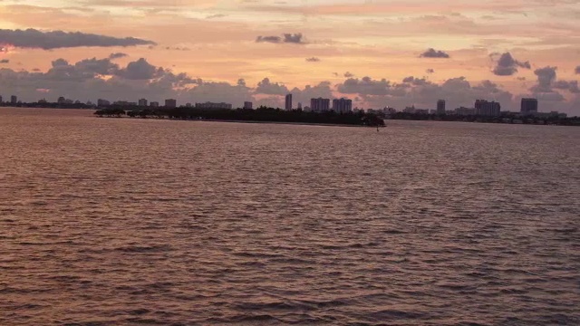 在迈阿密，夕阳下，飞机在平静的海面上滑行视频素材