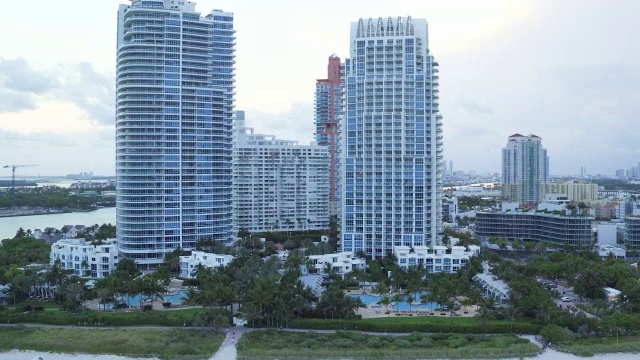 在迈阿密一个阴天的日落时分，沿着南海滩的海滩，空中缓慢地平移视频素材