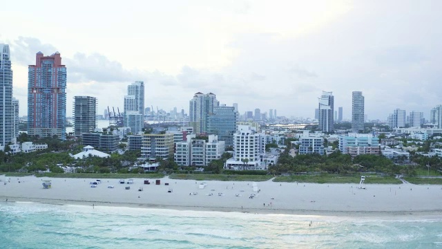 在迈阿密一个阴天的日落时分，沿着南海滩的海滩，空中缓慢地平移视频素材