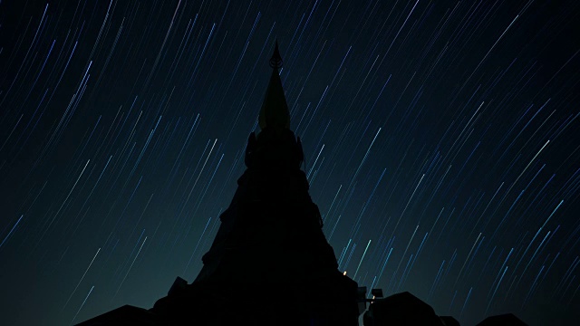 随着时间的推移，星星的轨迹在夜空与前景宝塔。视频素材