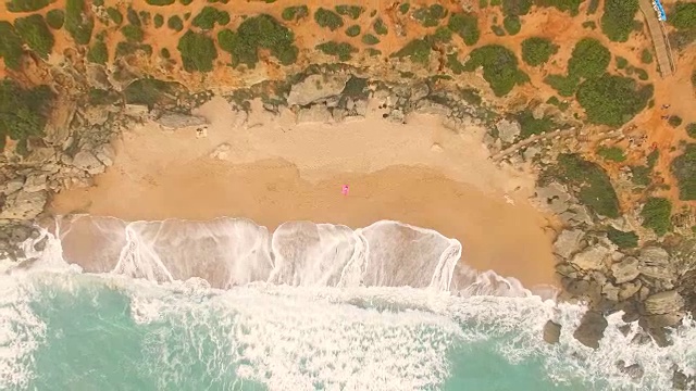 一个女人独自躺在一个惊人的和未被破坏的海滩在西班牙海岸的鸟瞰图视频素材