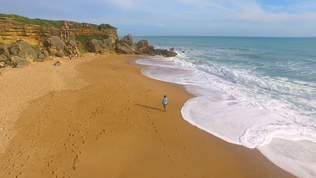 航拍的一个女人独自在一个惊人的和未被破坏的海滩在西班牙海岸视频素材