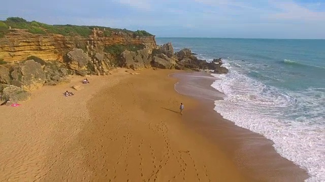 航拍的一个女人独自在一个惊人的和未被破坏的海滩在西班牙海岸视频素材