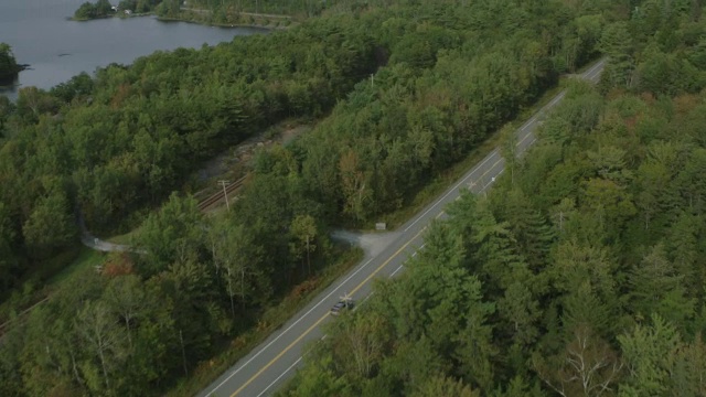 汽车在乡村或农村地区道路上行驶的天线。林中的树林中的树湖。视频素材