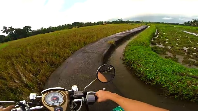 在巴厘岛旅行度假期间，夫妇从个人的角度记录道路使用行动摄像头，而骑摩托车在巴厘岛的道路。视频素材