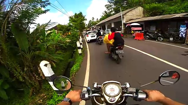 在巴厘岛旅行度假期间，夫妇从个人的角度记录道路使用行动摄像头，而骑摩托车在巴厘岛的道路。视频素材