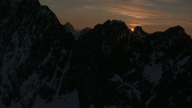 在黄金时间，空中飞向两座崎岖山峰之间的缝隙。视频素材